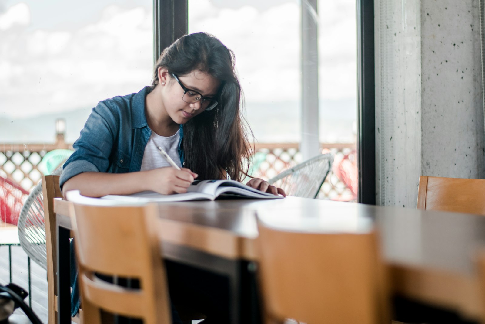 Student writing answers from memory in a notebook