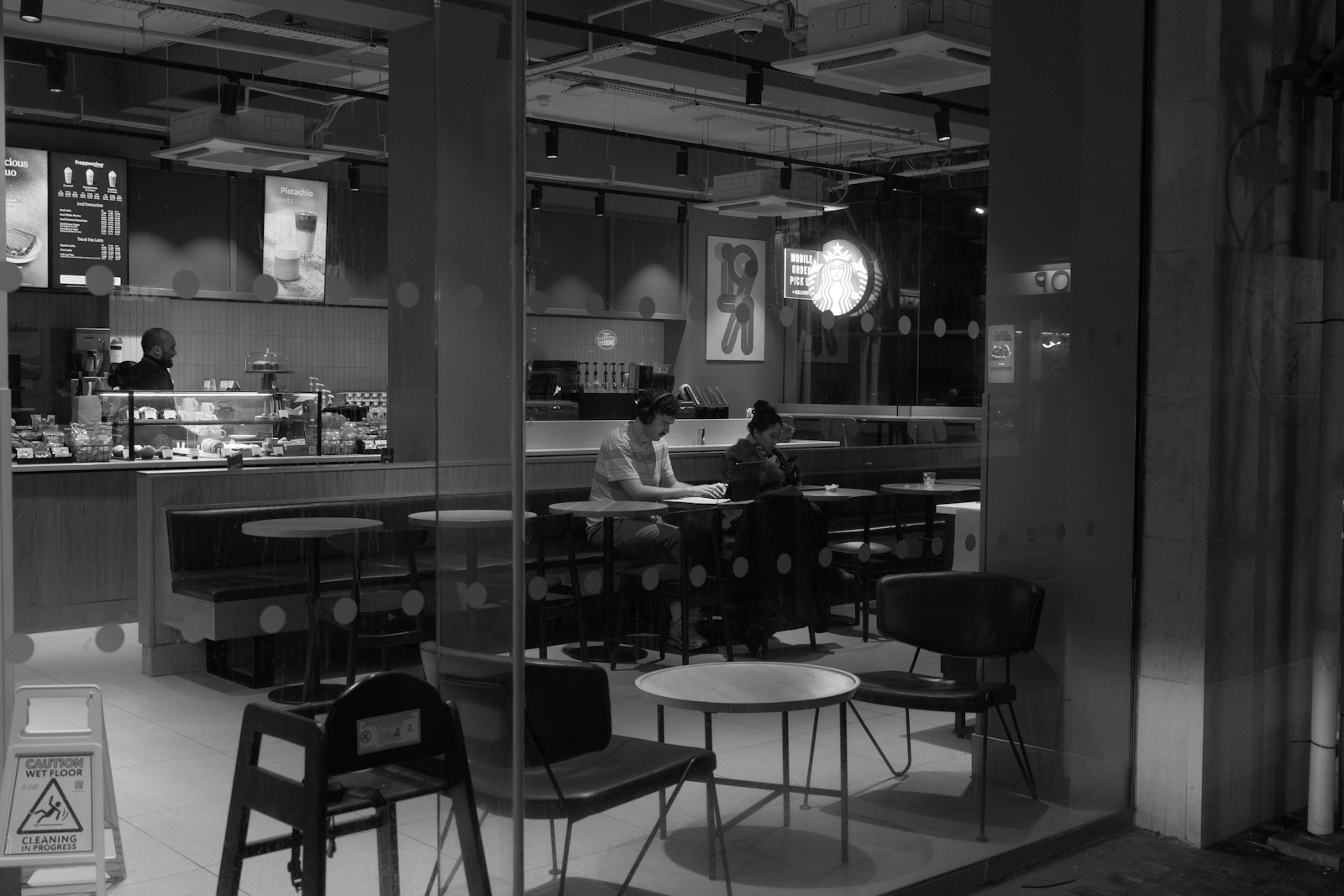 People studying on laptops in a cafe at night